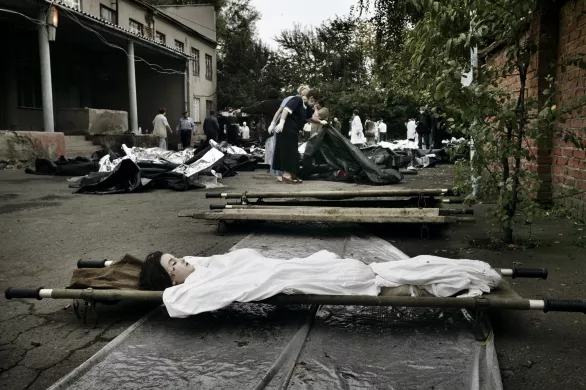 Эвакуация раненых заложников из здания школы в Беслане, 3 сентября 2004 года. Погибших детей - 186 / Фото: Юрий Козырев, NOOR